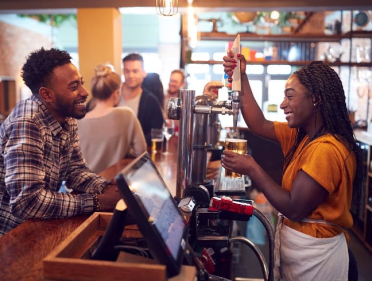 smiling-female-bartender-behind-counter-serving-fe-2023-11-27-04-57-33-utc-web